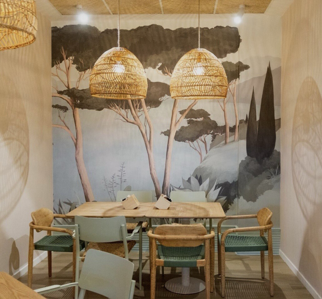 Comedor con mural pintado a mano y lámparas de mimbre